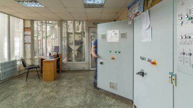 Fabrika Kontrol Paneli zaman ayarlı. Kontrol odası mühendisi. Mühendis kontrol odasındaki kontrol panelinin önünde duruyor ve düğmelere ve düğmelere basıyor.