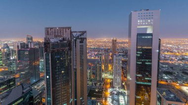 Katar 'ın Doha Zaman Çizelgesi' nde Batı Körfezi bölgesinin ufuk çizgisi. Aydınlatılmış modern gökdelenler. Gece güneş doğmadan çatıdan gökyüzü manzarası.
