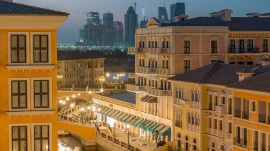 Doha İnci Bölgesi 'nin Venedik' teki Qanat Quartier 'i gibi köprü üstü manzaralı kanal, Katar' daki geçiş zamanı. Akşamki aydınlanma suya yansıdı. Arkaplanda gökdelen