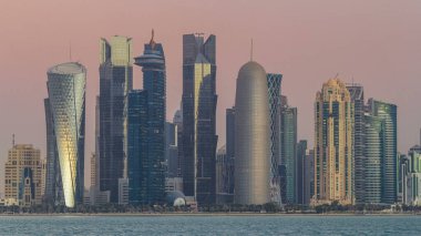 Arap şehri Doha 'nın ufuk çizgisi gece gündüz Katar' daki geçiş zamanı, gün doğumundan hemen önce aydınlık gökdelenlerle yakalandı. Corniche Gezinti Alanından Görünüm