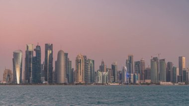 Arap şehri Doha 'nın ufuk çizgisi gece gündüz Katar' daki geçiş zamanı, gün doğumundan hemen önce aydınlık gökdelenlerle yakalandı. Corniche Gezinti Alanından Görünüm