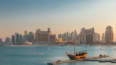 Katara Sahili 'nden Doha, Katar' da gün batımında Batı Körfezi 'ne ve şehir merkezine doğru bir görüntü. Öndeki eski gemi