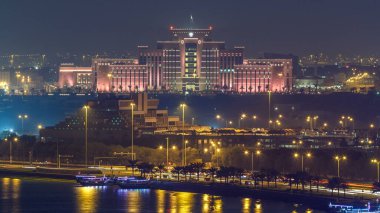 Doha Ufuk Çizgisi İçişleri Bakanlığı ve Posta Ofisi gece çizelgesi. Yukarıdan hava görüntüsü. Körfez suyundaki yansıma. Doha, Katar, Orta Doğu