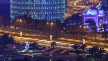 Doha Corniche ve kahve demliği anıtı. Havadan görünüşlü. Arka planda aydınlık gökdelenler ve yolda trafik