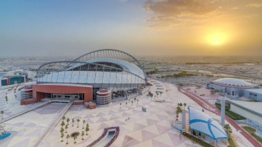 Doha 'da güneş doğarken Aspire Bölgesi' nin havadan görüntüsü. Yollarda ve araba parklarında trafik vardı. Sisli hava