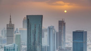Günbatımında gökdelenler başkent Katar 'ın ticaret merkezi Doha' nın ufuk çizgisinde. Sisli havada hava manzarası. Bulutlu turuncu gökyüzü