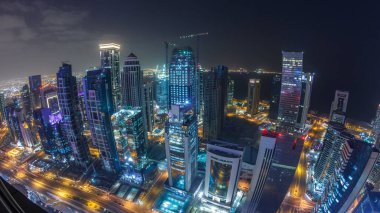 Katar 'ın Doha Zaman Çizelgesi' nde Batı Körfezi bölgesinin ufuk çizgisi. Aydınlatılmış modern gökdelenler geceleri çatıdan gökyüzü manzarası. Yollarda trafik vardı. Fisheye merceği
