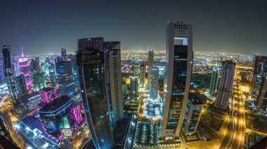 Katar 'ın Doha Zaman Çizelgesi' nde Batı Körfezi bölgesinin ufuk çizgisi. Aydınlatılmış modern gökdelenler geceleri çatıdan gökyüzü manzarası. Yollarda trafik vardı. Fisheye merceği
