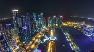 Katar 'ın Doha Zaman Çizelgesi' nde Batı Körfezi bölgesinin ufuk çizgisi. Aydınlatılmış modern gökdelenler geceleri çatıdan gökyüzü manzarası. Yollarda trafik vardı. Fisheye merceği