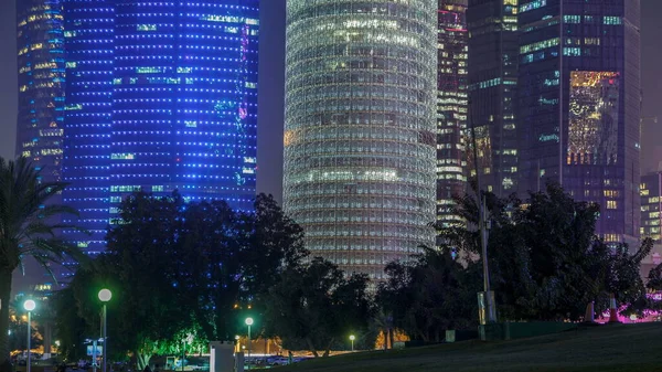 Doha 'nın yüksek katlı bölgesinde gece vardiyası, parktan görülmüş. Batı körfezinde aydınlatılmış gökdelenler ve palmiyeler