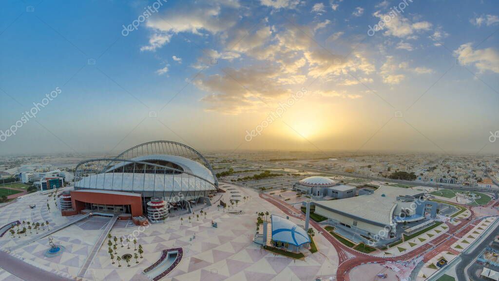 Aerial view of Aspire Zone from top at sunrise timelapse in Doha. Traffic on the road and car parking. Foggy weather