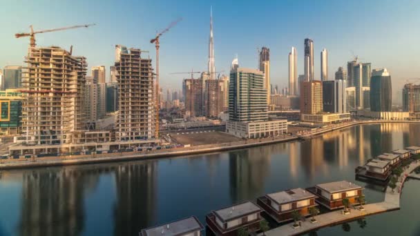파란 하늘을 배경으로 두 바이 운하 근처에 있는 고층 건물 들 — 비디오