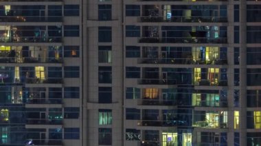 Geceleri apartmanda insanların oturduğu parlak pencereler..
