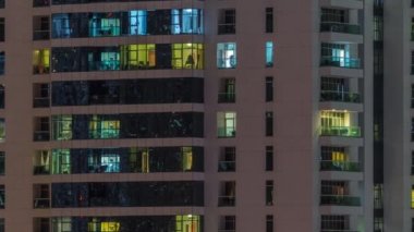 Geceleri apartmanda insanların oturduğu parlak pencereler..