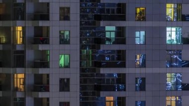 Geceleri apartmanda insanların oturduğu parlak pencereler..