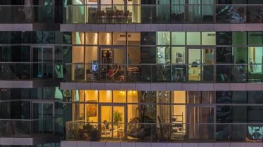 Geceleri apartmanda insanların oturduğu parlak pencereler..