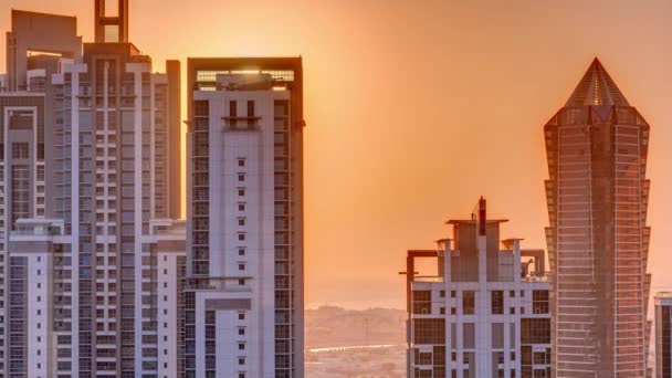ドバイのビジネスベイで現代的な住宅やオフィス複合空中タイムラプスの後ろの夕日 — ストック動画