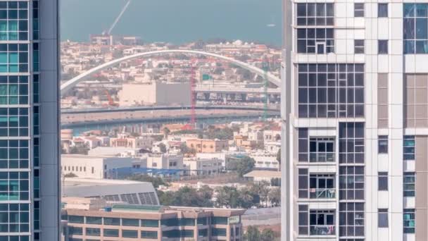 Jalankulkijoiden silta yli Dubain vesikanavan antenni aikajänne välillä tornit Business Bay ylhäältä — kuvapankkivideo