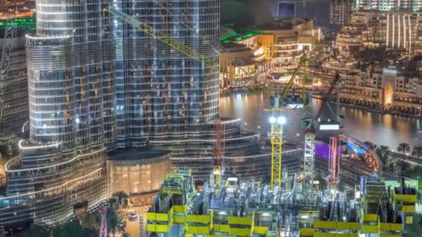 Vista aérea de um arranha-céu em construção com enormes guindastes noite timelapse em Dubai . — Vídeo de Stock