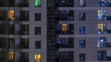 Geceleri apartmanda insanların oturduğu parlak pencereler..