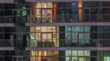 Geceleri apartmanda insanların oturduğu parlak pencereler..
