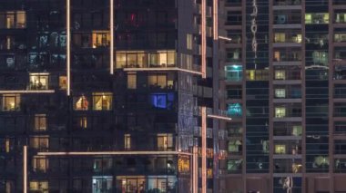 Geceleri apartmanda insanların oturduğu parlak pencereler..