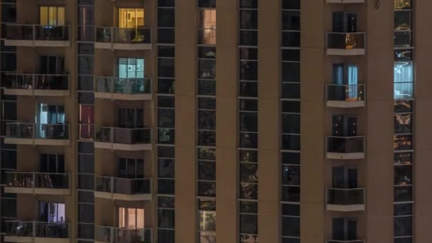 Righe di finestre luminose con persone in condominio di notte . — Video Stock