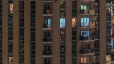 Geceleri apartmanda insanların oturduğu parlak pencereler..