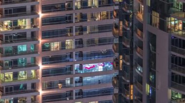 Geceleri apartmanda insanların oturduğu parlak pencereler..