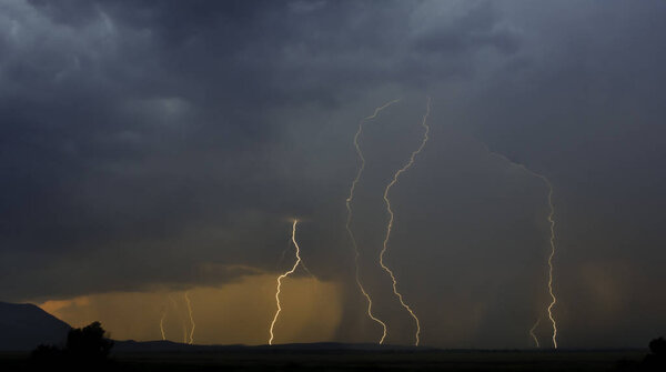 Облачное небо с видимыми молниями во время дождя в горах Ян
