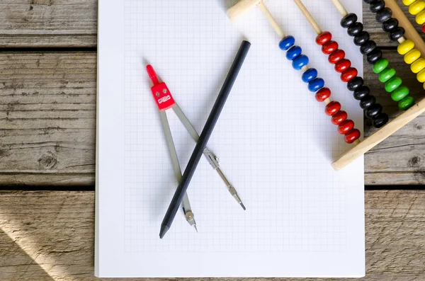 Cahier ouvert de mathématiques avec comptage coloré abaque et compas en acier — Photo