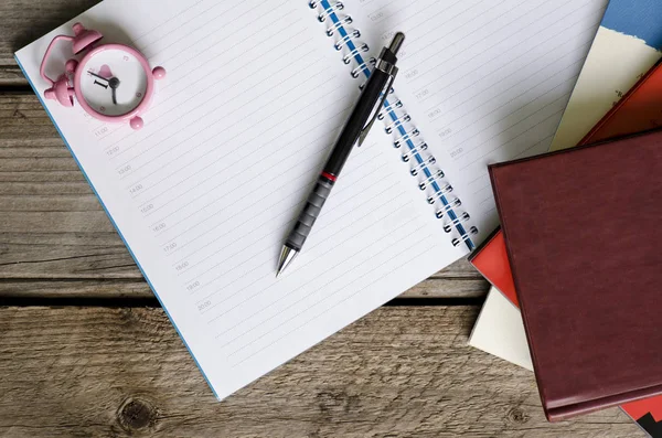 Agenda de caderno aberto com calendário e monte de livros com smal — Fotografia de Stock