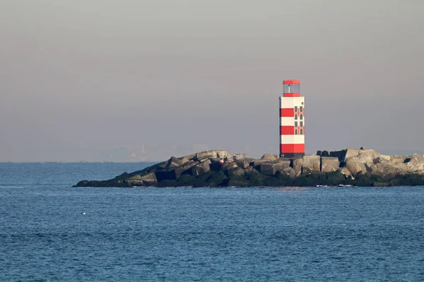 Fyren på stenig strand — Stockfoto