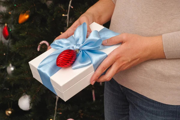 Woman holding christmas gift in her hands — Stock Photo, Image