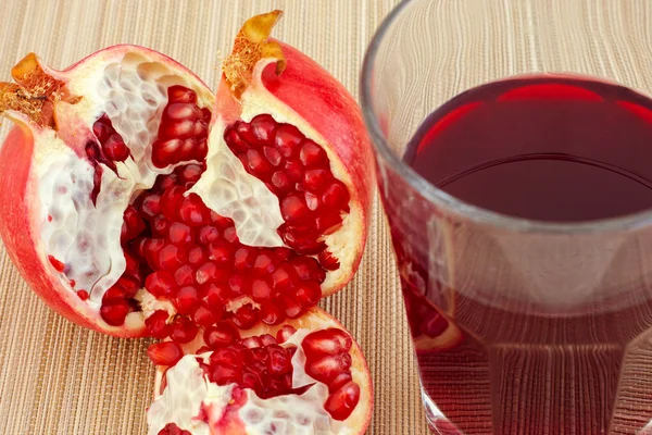 Granada madura y jugo en un vaso — Foto de Stock