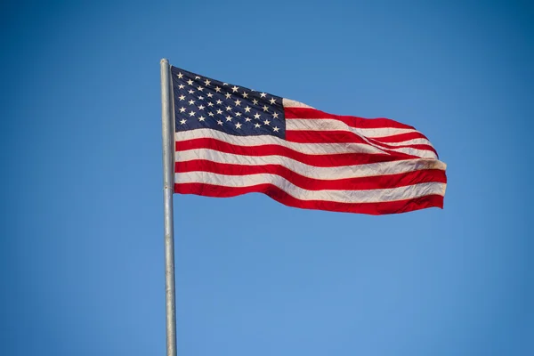 Americká vlajka proti modré obloze — Stock fotografie