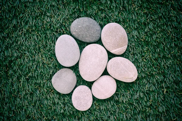 Stelletje stenen liggend op groen gras — Stockfoto