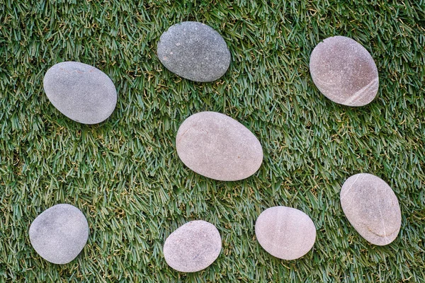 Stelletje stenen liggend op groen gras — Stockfoto