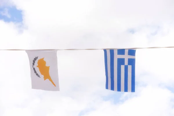 Banderas de Grecia y Chipre contra el cielo azul nublado —  Fotos de Stock