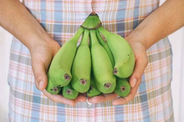 Bunch of green organic bananas in hands — Stock Photo, Image