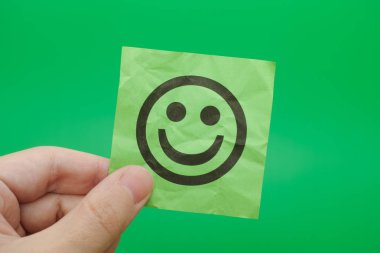 Mutlu yüz ile yeşil kağıt Not tutan kişi