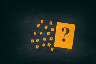 Kara tahta üzerinde soru işaretleri ile sarı kağıt notları