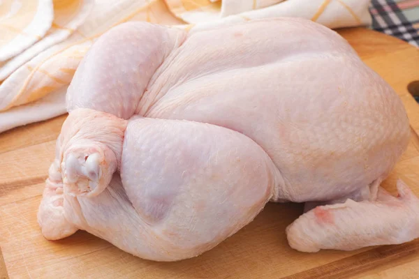 Fresh whole raw chicken on wooden cutting board — Stock Photo, Image