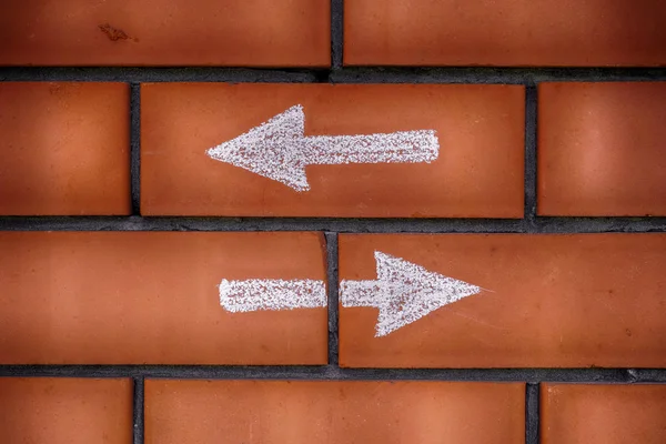 Two arrows pointing forward and backward drawn on bricks — Stock Photo, Image