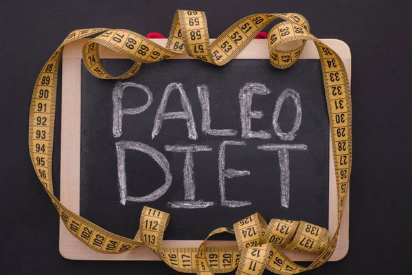 Measuring tape on blackboard with the words Paleo Diet — Stock Photo, Image