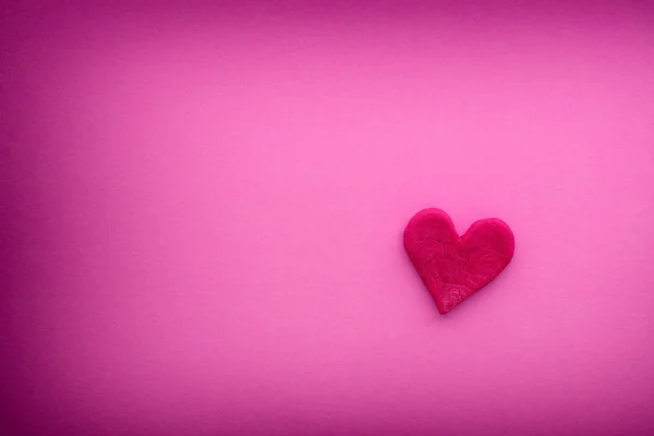 Cuore rosso con piccole crepe su uno sfondo rosa — Foto Stock