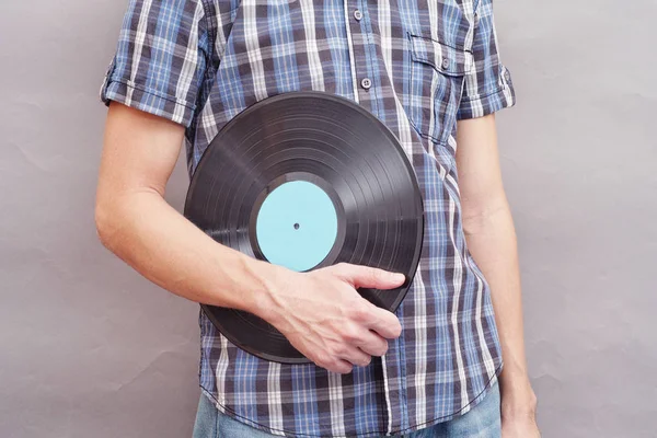 Man holds vinyl record in his hand — Stock Photo, Image