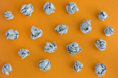 Gri buruşuk kağıt topları sarı bir arka plan üzerinde