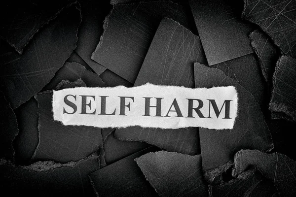 Self Harm. Torn pieces of black paper and words Self Harm. Conce — Stock Photo, Image