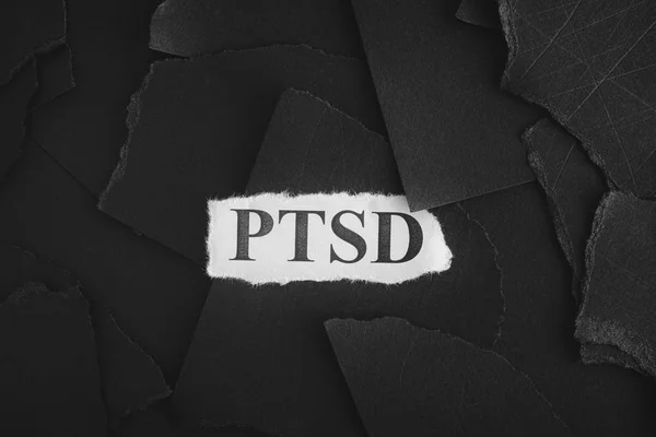 Zerrissene Stücke schwarzen Papiers und Wörter posttraumatische Belastungsstörung — Stockfoto